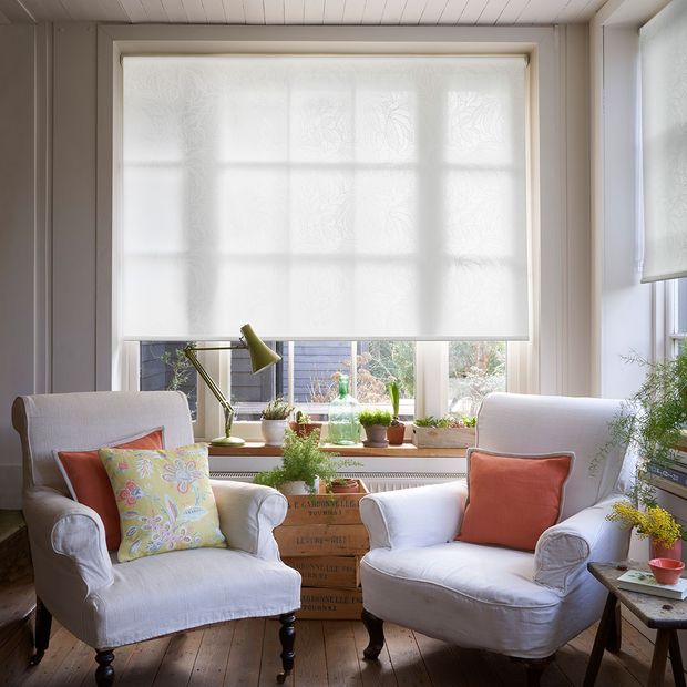 Living room with two white armchairs and white roller blinds
