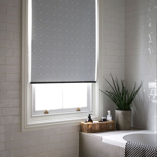 Minimalist bathroom in natural stone with white tiles and a blackout roller blind