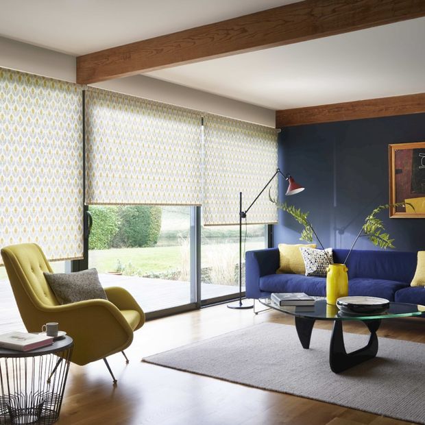 Modern living room with retro style decor and wide windows dressed with retro yellow floral roller blinds