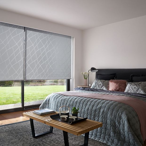 A Grey Patterned Roller Blind in Silver in a one bed Bedroom