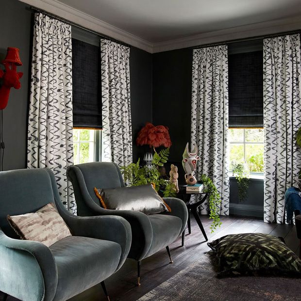 Dark, edgy living room with various textures and prints and dark grey roman blinds