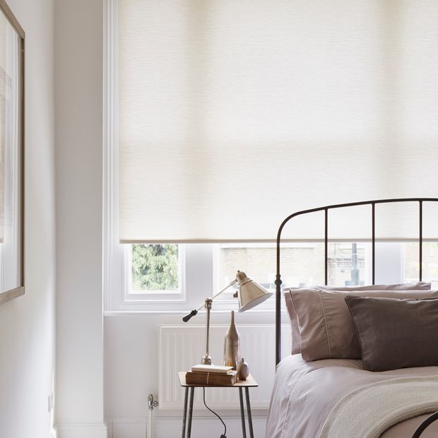 Plain Norfolk Ivory roller blind hung in bedroom