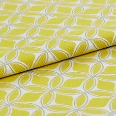 white fabric decorated in yellow with a geometric design that repeats across the material