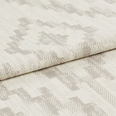 Cream coloured fabric with grey highlights that are scattered in a repeating pattern across the whole fabric