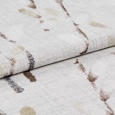 Folded white fabric with a repeating leaf and stem patterns