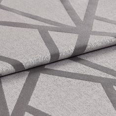 Folded fabric that has a light grey base grey and dark grey geometric lines