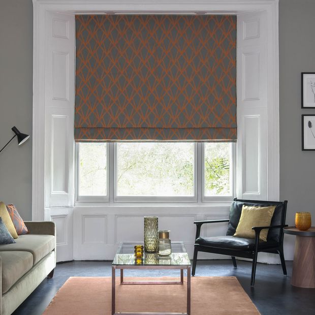 Dimension Ember geometrical patterned Roman blinds in grey and copper in a grey living room