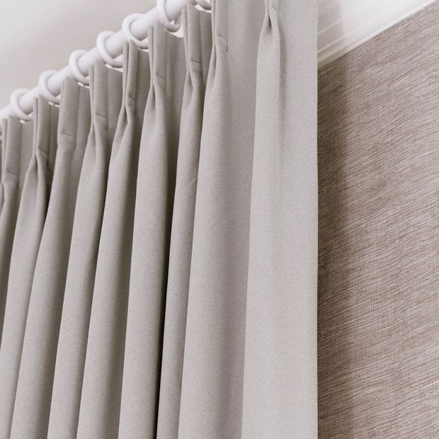 Close up of double pinch pleat header type on white curtain pole