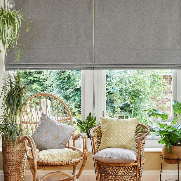 A conservatory with two wicker chairs