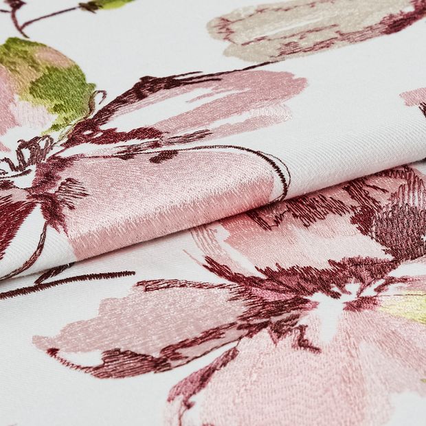 White coloured fabric with woven flowers on the material in a watercolour style