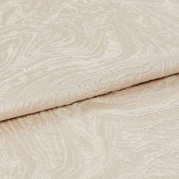 Cream and white coloured fabric in a repeating swirling pattern