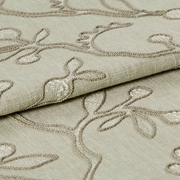 Neutral coloured fabric which has been folded is decorated with a repeating leaf and stem design
