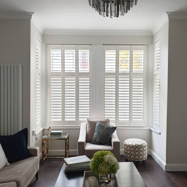 White shutters installed on bay windows of living room