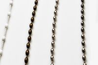 A close up image of the chains that are used to adjust roman curtains