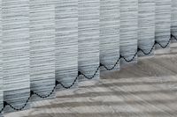 a close up image of vertical blinds showing the black coloured chain that connects them