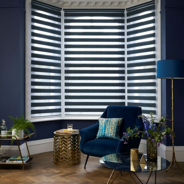 Navy day and night blind with navy wall, navy and gold lamp and plush navy sofa chair