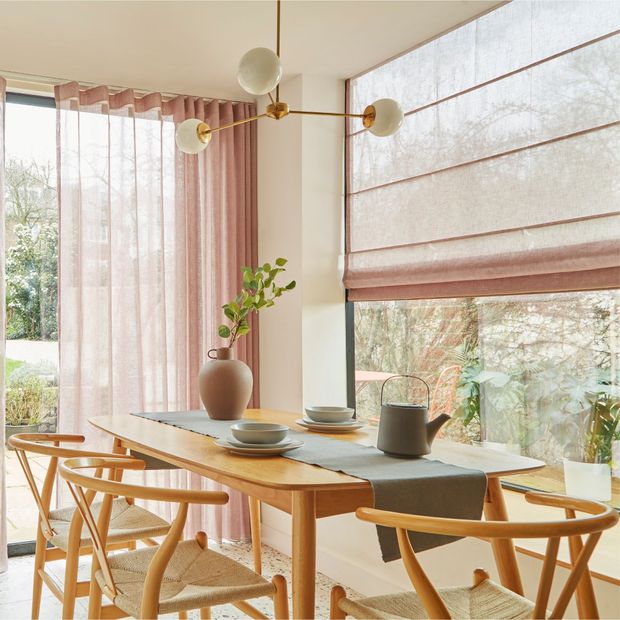 Pink voile curtain and roman blind fitted to large windows in a spacious dining room