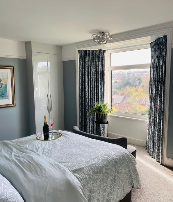 Navy and light blue floral print, pencil pleat curtains in a modern, muted bedroom