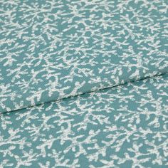 A folded piece of fabric with Coral Pacific Teal printed on it