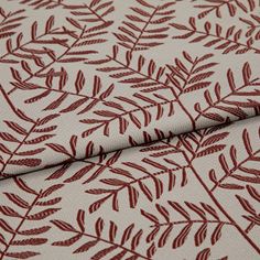 A folded piece of fabric with Fronds Beetroot Red printed on it