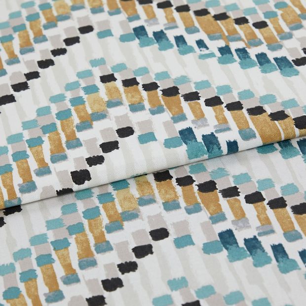 A folded piece of fabric with Holi Aquarelle Teal printed on it