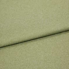 A folded piece of fabric with Huxley Moss Light Green printed on it