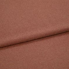 A folded piece of fabric with Huxley Rust Orange printed on it