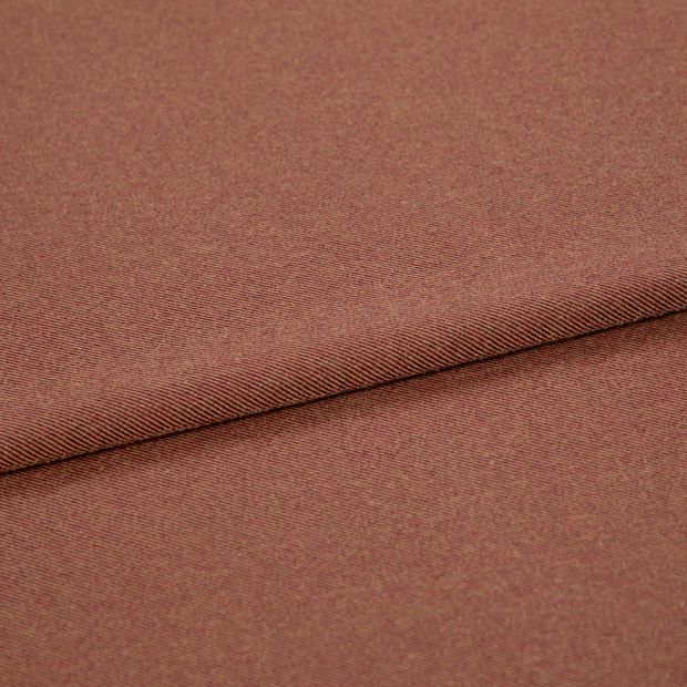 A folded piece of fabric with Huxley Rust Orange printed on it