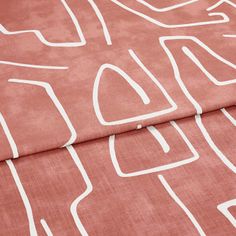A folded piece of fabric with Nora Bruschetta Red printed on it