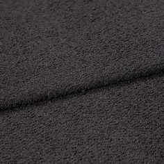 A folded piece of fabric with Soho Bouclé Charcoal Black printed on it