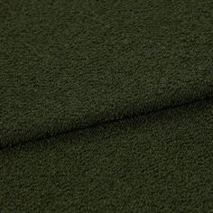 A folded piece of fabric with Soho Bouclé Forest Green printed on it