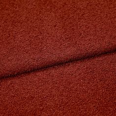 A folded piece of fabric with Soho Bouclé Spice Red printed on it