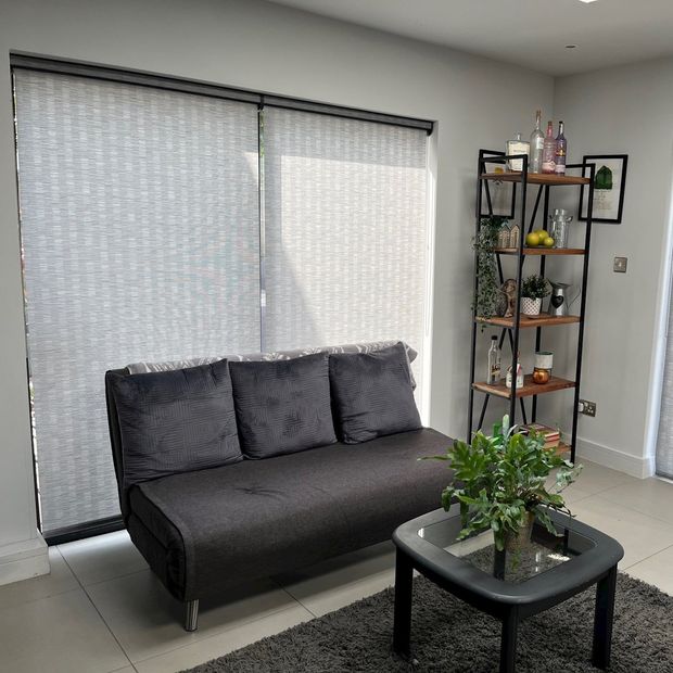 Fully closed grey bengal monument roller blinds in living room conservatory area