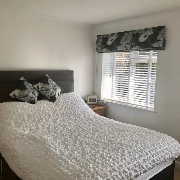Monroe smoulder roman blind in bedroom with matching cushions