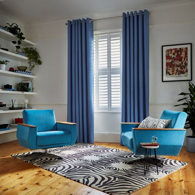 Faso cornflower blue eyelet curtains paired with white shutters in living room