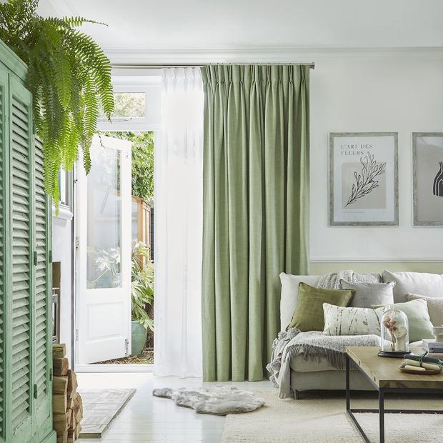 Pearl olive green floor length pinch pleat curtains paired with voiles in cosy living room