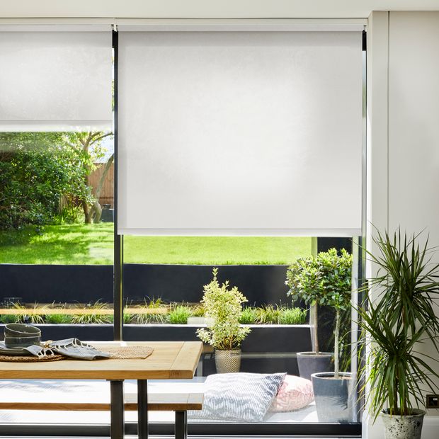 Marco whitewash electric roller blind on wide windows in dining room