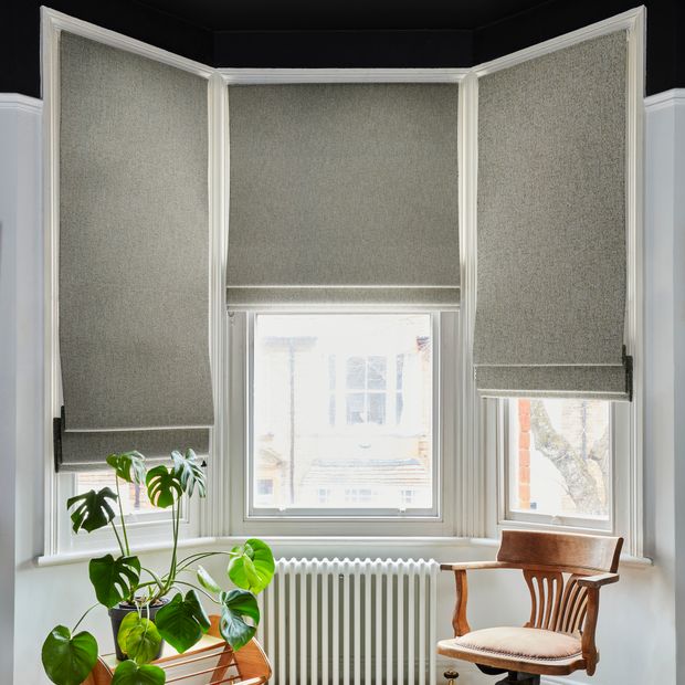 Set of three paloma tan roman blinds on bay window in living room