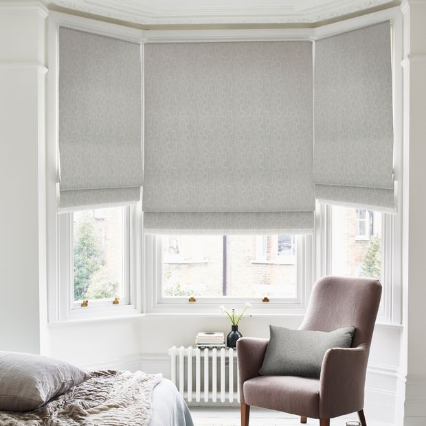 power steel roman blinds on bay window in bedroom