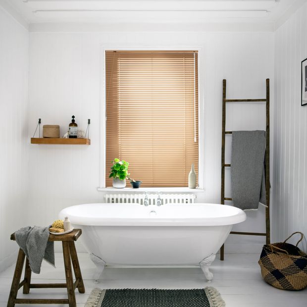 Latte brown metal venetian blinds in bathroom above bath