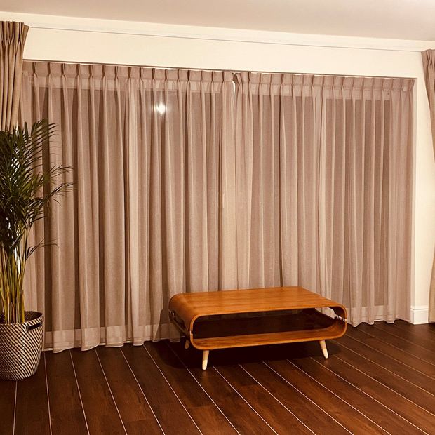 light pink/purple voile curtains in open wooden floored dining room