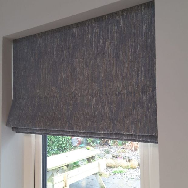 Islita charcoal dark grey roman blind in small window in living room