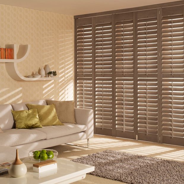 antique oak dark brown wooden tracked shutters on a living room window