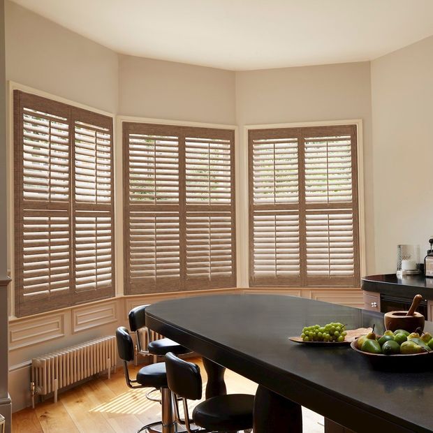 three cherry oak shutters on windows in a kitchen with island