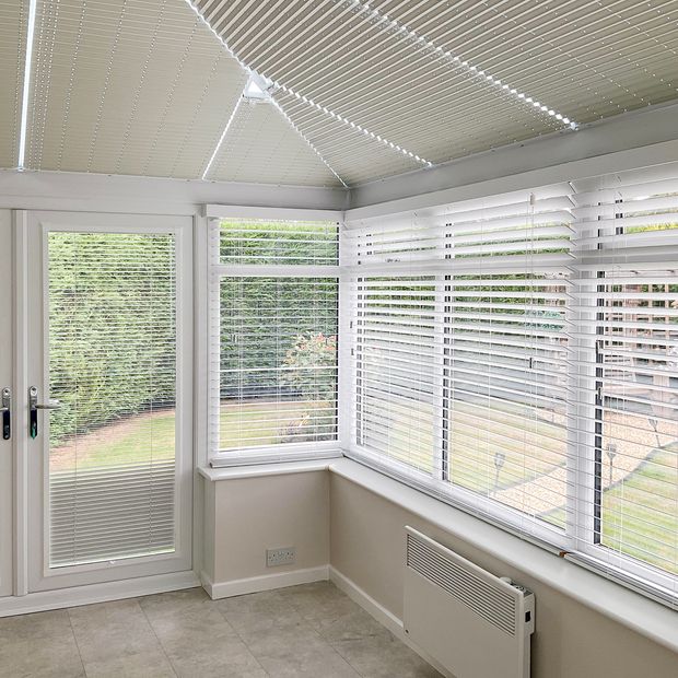 white metal venetian blinds on conservatory windows