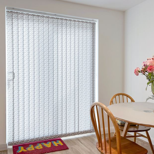 harriet ocean depths patterned vertical blinds on sliding patio doors in dining room with wooden furniture