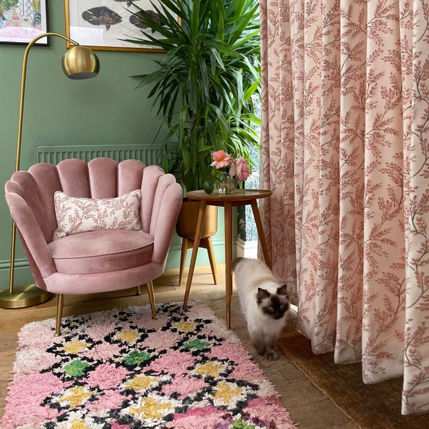 pink floral roman blind and curtain in kitchen/living area with floral patterned walls and furnishings