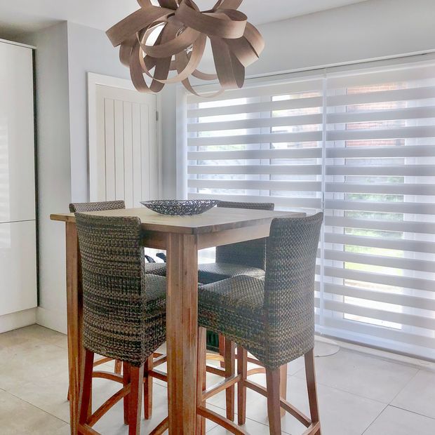 white day and night blinds on patio doors in dining area with high chairs and a tall wooden table