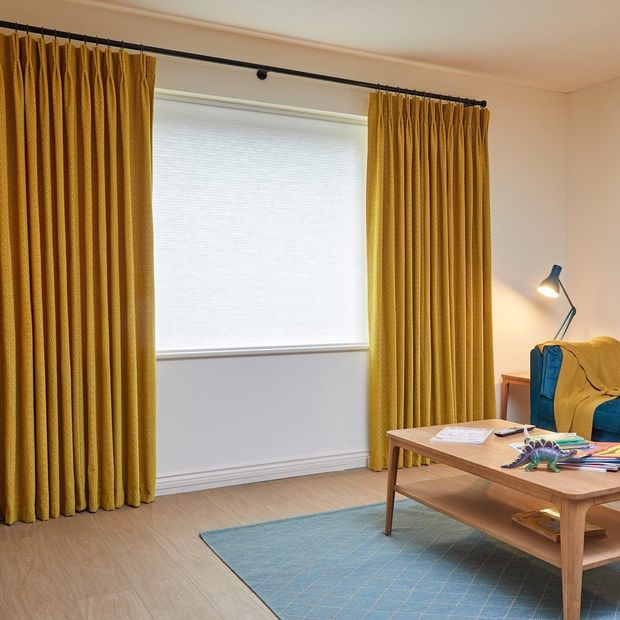 wave Sulphur pinch pleat curtains paired with pleated blinds in slightly cluttered living room