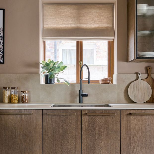 beige roman blind on kitchen window above the sink